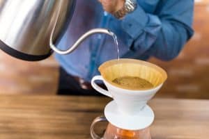 Make coffee pour-over by using steaming water and a filter basket.