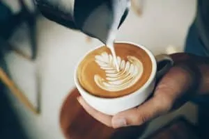 Pouring steamed milk into a cappuccino or latte