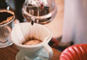 Using the traditional method to pour hot water over the coffee grounds to brew a cup of joe!