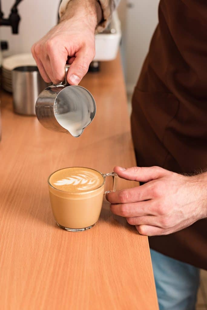 Pouring Steamed milk to make a Cortado